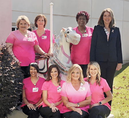 Healthcare staff in pink with awareness sculpture.