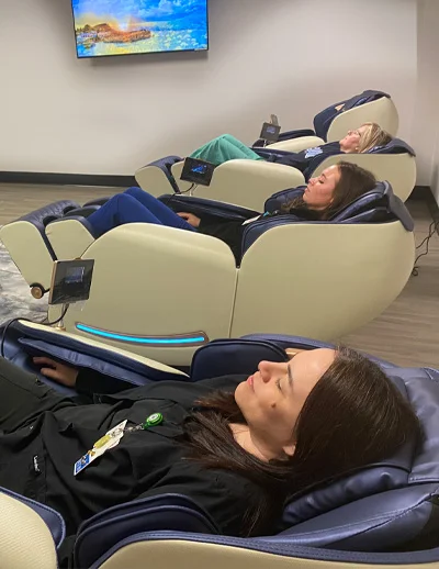 People relaxing in massage chairs.