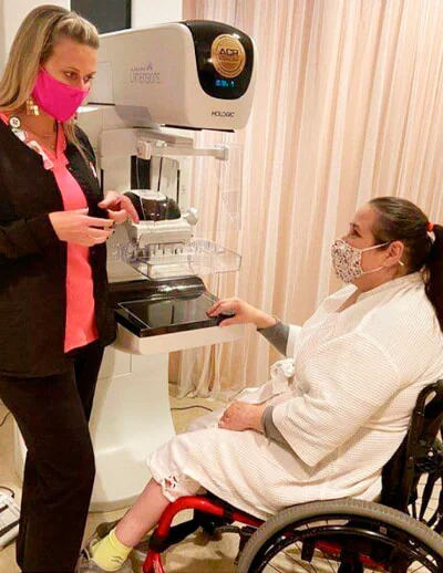 Woman in wheelchair receiving mammogram exam.