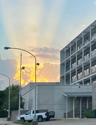 Sunset rays over urban parking structure.
