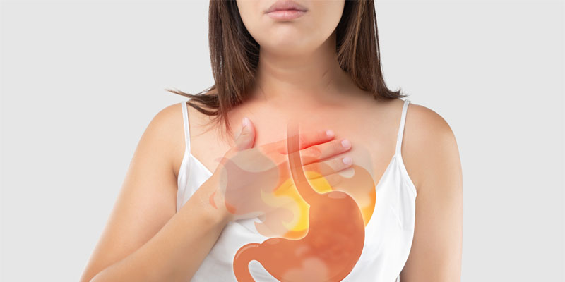 Woman experiencing heartburn, graphic overlay of stomach.