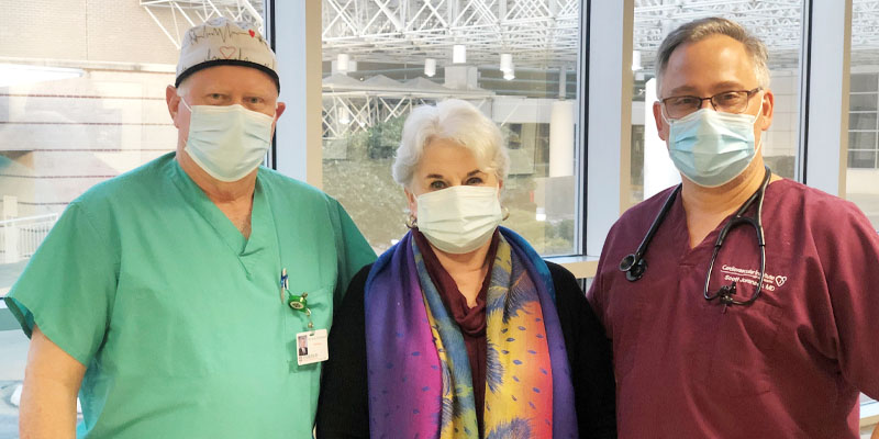 Three healthcare professionals wearing masks indoors.