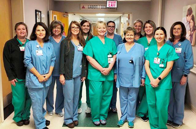 Group of healthcare professionals smiling in a hallway