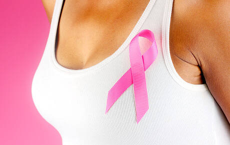 Breast cancer awareness pink ribbon on white tank top.