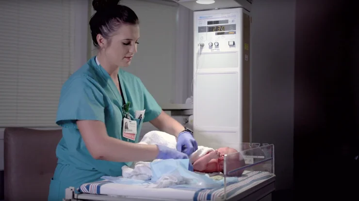 Nurse caring for newborn baby in hospital