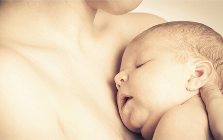 Newborn baby sleeping peacefully on mother's chest.