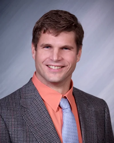Smiling man in suit for professional headshot.