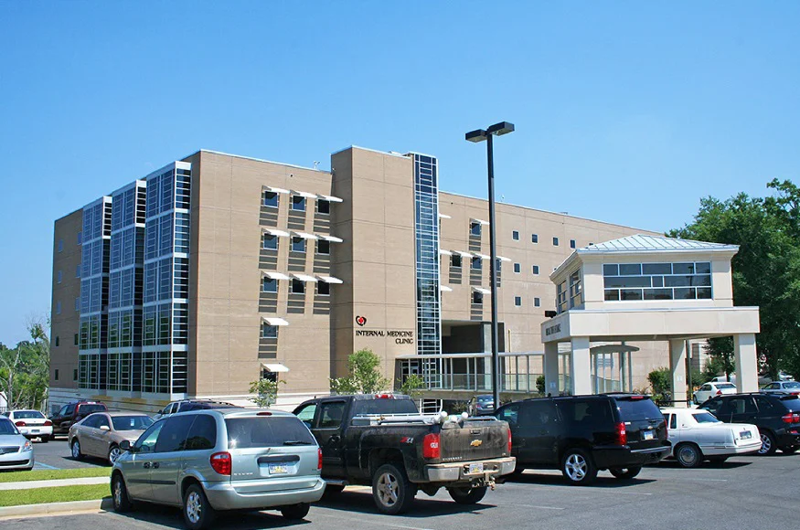 Modern hospital building with parking lot.
