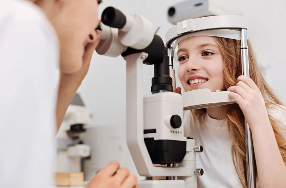 Girl undergoing eye examination with phoropter.