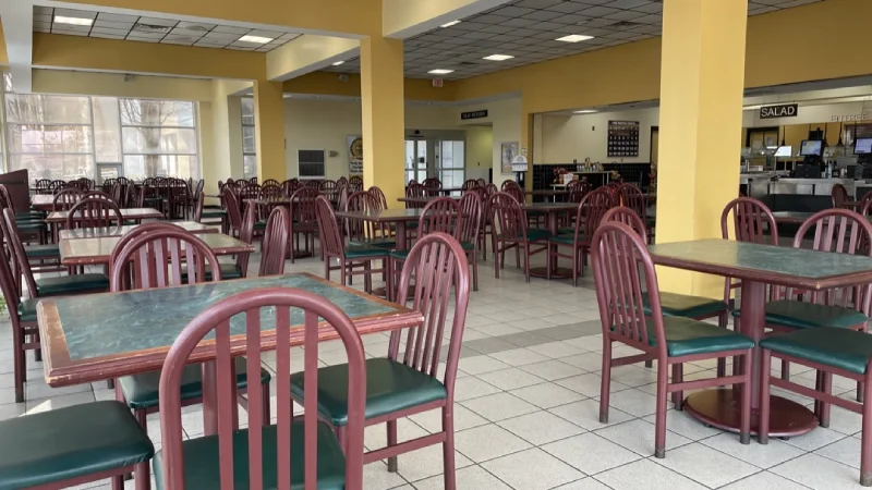 Empty cafeteria interior with tables and chairs.
