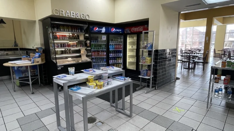 Convenience store interior with snacks and beverage fridges.