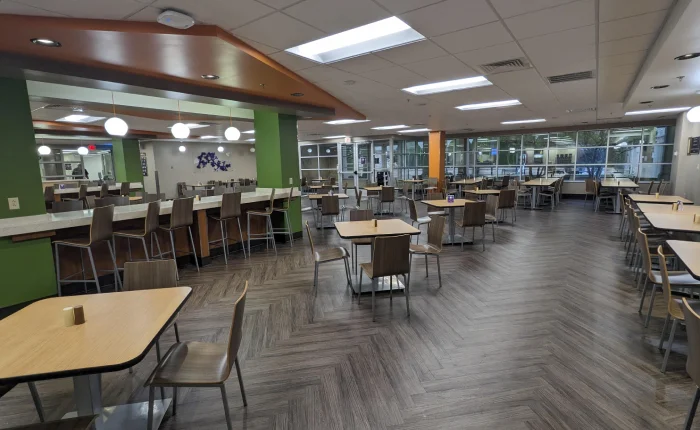Empty modern cafeteria with tables and chairs.