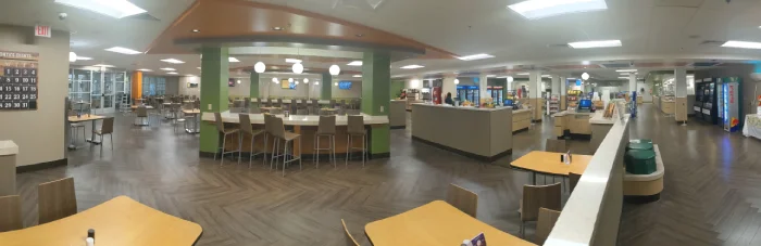 Spacious, modern cafeteria with seating and serving stations.