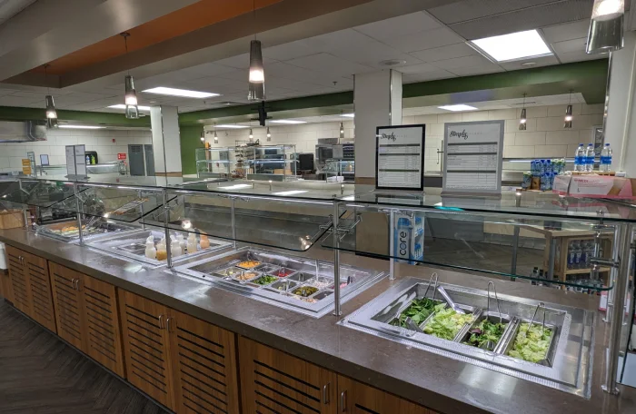 Modern cafeteria serving line with salad bar.